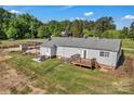 Backyard view featuring a deck with stairs, patio with chairs, and a well-maintained lawn at 159 Old Home Pl, China Grove, NC 28023