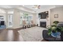 Inviting living room with fireplace, large windows, and hardwood floors at 16112 Lakeside Loop Ln, Cornelius, NC 28031