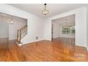 Open living room with hardwood floors, elegant lighting, and staircase view at 1654 Scotch Pine Ln, Fort Mill, SC 29708