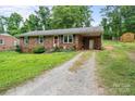 Charming brick home with covered front porch, and a gravel driveway at 205 Pinehurst Dr, Kings Mountain, NC 28086