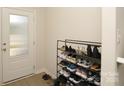 Cozy entryway featuring a shoe rack filled with various pairs of shoes and a glass paneled door at 2210 Transatlantic Ave, Charlotte, NC 28215