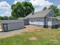 View of the backyard showing a storage shed and the home's light gray exterior at 225 N Main St, Mount Pleasant, NC 28124