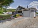 Gray home featuring a covered front porch and convenient attached one car garage at 225 N Main St, Mount Pleasant, NC 28124