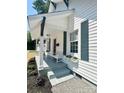 Inviting front porch with a classic white bench, window boxes, and freshly landscaped yard at 229 W Gray Ave, Mooresville, NC 28115