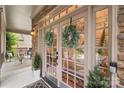 Charming entryway with double glass doors adorned with wreaths, stone facade, and cozy front porch at 2817 Bevis Ln, Waxhaw, NC 28173