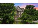 Charming two-story home with brick facade, mature trees, and beautiful twilight sky at 2817 Bevis Ln, Waxhaw, NC 28173