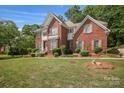 Well-maintained brick two-story home with manicured lawn, charming shutters and lush landscaping at 3104 Highgate Dr, Fort Mill, SC 29715