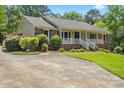 Inviting ranch-style home featuring a manicured lawn, brick accents, and a charming front porch, perfect for outdoor enjoyment at 3712 Eaglebrook Dr, Gastonia, NC 28056