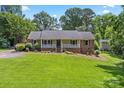 Lovely single-story home with a lush green lawn and inviting front porch nestled amongst mature trees at 3712 Eaglebrook Dr, Gastonia, NC 28056