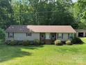 Inviting home exterior features red shutters, porch, and beautiful landscaping at 4225 Stewart Rd, Claremont, NC 28610