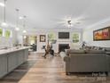 Open-concept living space with fireplace, wood floors, and a sliding door to backyard at 4316 Falls Lake Sw Dr, Concord, NC 28025