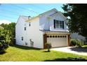 Exterior view of a two-story white home with a lush green lawn and a well-manicured garden at 6614 Wicked Oak Ln, Charlotte, NC 28216