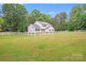 Charming two-story home with a well-manicured lawn, surrounded by a white fence at 6910 Birdsong Ln, Waxhaw, NC 28173