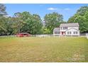 Expansive green yard with a white fence around a two-story home and a small barn at 6910 Birdsong Ln, Waxhaw, NC 28173