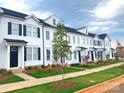 Exterior view of townhomes featuring white siding, black shutters and well-maintained landscaping at 8114 Jacey Ln # 21, Huntersville, NC 28078