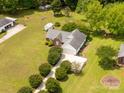 Overhead shot of a well-maintained brick home with a green lawn, outbuildings, and mature trees at 819 Riddle Mill Rd, Clover, SC 29710