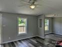 A bright living room featuring gray walls, new wood-style vinyl flooring, and natural light from two windows at 874 Old Home Place Way, Lincolnton, NC 28092
