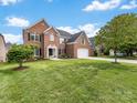 Charming brick home with manicured lawn, mature trees, and attached two car garage at 9923 Paradise Ridge Rd, Charlotte, NC 28277