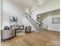 Bright, two-story living room showcasing a staircase, modern furniture, and light hardwood floors at 9923 Paradise Ridge Rd, Charlotte, NC 28277