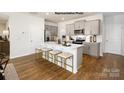 Modern kitchen with a large island, seating, stainless steel appliances, gray cabinets, and hardwood floors at 1023 Hostler Ln, York, SC 29745