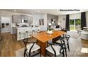 Open-concept living space featuring a kitchen with island seating, a dining area, and a cozy living room with natural light at 1023 Hostler Ln, York, SC 29745