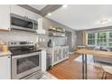 Well-lit kitchen showcases stainless steel oven, updated microwave, breakfast bar, and adjacent living room at 1100 Mona Dr, Charlotte, NC 28206