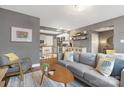 Comfortable living room with modern decor, plush sofa, and views into the updated kitchen at 1100 Mona Dr, Charlotte, NC 28206