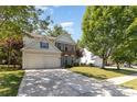 Beautifully landscaped front yard with mature trees and a spacious driveway leading to a two-car garage at 11807 Hawick Valley Ln, Charlotte, NC 28277