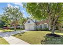 Well-maintained front yard showcasing a two-story home with a lush lawn and mature trees at 11807 Hawick Valley Ln, Charlotte, NC 28277