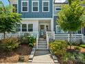 Inviting townhome entrance with a white picket fence, beautiful landscaping, and covered porch at 119 Berkeley Ave # A, Mooresville, NC 28117