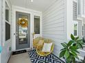 Cozy front porch featuring stylish yellow seating, a welcoming mat, and a cheerful sunflower wreath at 119 Berkeley Ave # A, Mooresville, NC 28117