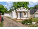 Charming white brick home with a cozy front porch and driveway on the side at 1211 N Boyce St, Gastonia, NC 28052