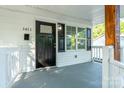 Close-up of the front porch, showcasing wooden columns, white railings, and a black front door at 1411 Caldwell St, Gastonia, NC 28052