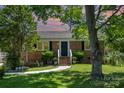 Charming brick home with a manicured lawn and mature trees at sunset at 145 Driftwood Dr, Mooresville, NC 28117