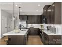 A modern kitchen is showcased with a large island, barstool seating, stainless steel appliances, and ample cabinet space at 1656 Respect Nw St, Concord, NC 28027