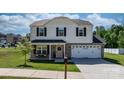 Charming home featuring a front porch with chairs, a pink front door with a green wreath, and manicured lawn at 1925 Maius Dr # 30, Conover, NC 28613