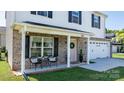 Charming front porch with seating, complemented by a pink door adorned with a wreath and decorative plants at 1925 Maius Dr # 30, Conover, NC 28613
