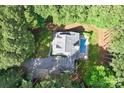 An aerial view showing the home surrounded by mature trees with a private pool and a long driveway at 1956 Forest Ridge Dr, Stanley, NC 28164