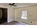 Partially renovated living room featuring new wood floors, a ceiling fan, and ample natural light at 2131 Barnett St, Lancaster, SC 29720