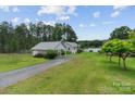 Quaint property featuring a charming house and separate garage or workshop, all surrounded by lush greenery and a serene waterfront at 281 Emerald Shores Rd, Mount Gilead, NC 27306