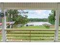Picturesque view of the lake and surrounding greenery from the wooden porch of the home, showcasing the beauty of nature at 281 Emerald Shores Rd, Mount Gilead, NC 27306