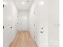 Bright hallway featuring white walls, a light wood floor, and multiple doors, creating a seamless transition throughout the home at 2813 New Pineola Rd, Charlotte, NC 28208