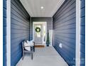 Inviting front porch featuring wood siding, a decorative wreath, seating, and a welcome sign at 3103 Oliver Stanley Trl, Lancaster, SC 29720