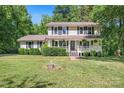 Two-story house with a welcoming front porch, American flag, and landscaped front yard at 335 Bob White Run, Salisbury, NC 28147