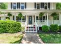 Inviting front porch with white railings, hanging plants, and pink potted flowers on the steps at 335 Bob White Run, Salisbury, NC 28147