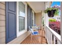 Cozy front porch with brick flooring, blue shutters, seating, and hanging plants, offering a relaxing outdoor space at 3864 Meadow Ridge Nw Dr, Concord, NC 28027