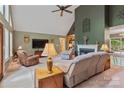 Open living room with fireplace, ceiling fan, and access to the kitchen and back deck at 4038 Forest Brook Dr, Edgemoor, SC 29712