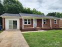 Single story brick home with white trim, covered porch and freshly landscaped front yard at 409 S Martin Luther King Jr Ave, Salisbury, NC 28144