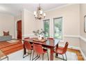 Formal dining room featuring a wooden table with seating for six, a chandelier, and natural light from two large windows at 4509 Rosecliff Dr, Charlotte, NC 28277