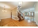 Spacious foyer with hardwood floors, staircase with iron spindles, and chandelier lighting at 4509 Rosecliff Dr, Charlotte, NC 28277